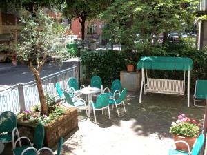 un patio con sillas, una mesa y un árbol en Hotel Pierina, en Castrocaro Terme