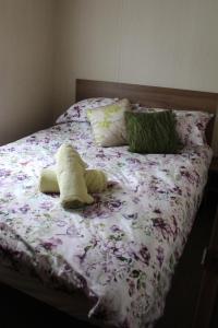 un letto con un mazzo di fiori sopra di 3 Bed Static Caravan @ Hoburne Devon Bay a Paignton