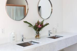 a bathroom with two sinks and two mirrors at Mendocino Grove in Mendocino