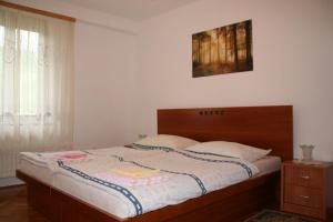 Schlafzimmer mit einem großen Bett mit einem Kopfteil aus Holz in der Unterkunft Apartment Bric in Kobarid