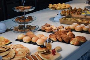 a table filled with different types of pastries and bread at Hannah's Studios in Porto