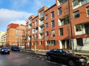 een zwarte auto geparkeerd voor een bakstenen gebouw bij Ideal Apartments Green & Blue in Gdańsk