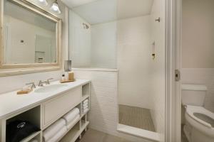 a bathroom with a sink and a toilet and a mirror at Jekyll Ocean Club Resort in Jekyll Island