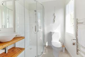 a bathroom with a shower and a toilet and a sink at Eight on Church - near Mudbrick & Cable Bay in Oneroa +9 photos