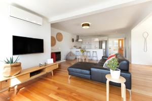 a living room with a couch and a tv at Eight on Church - near Mudbrick & Cable Bay in Oneroa