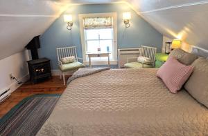 a bedroom with a bed and two chairs and a window at Elms of Camden in Camden