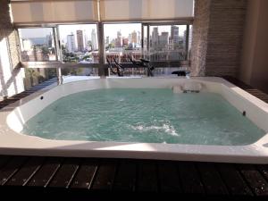 uma banheira de hidromassagem com vista para a cidade em Apart Belgrano em Posadas