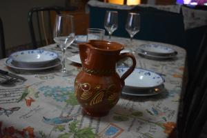 una mesa con jarrón, platos y copas de vino en La Casassa II, en Les Coves de Vinroma