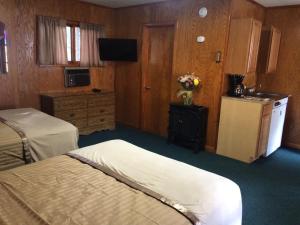 a hotel room with two beds and a television at The Meadows in Lake George