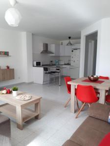 a living room and kitchen with red chairs and a table at Tu rincon en Playa de Melenara in Telde
