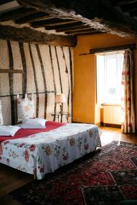 蓬托尔松La Vieille Foulonnière : Chambres d'hôtes & Permaculture的带床和窗户的卧室
