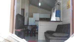 sala de estar con sofá y cocina en Linda casa, en Florianópolis