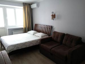 um pequeno quarto com uma cama e um sofá em New apartment on Starokyivska 1/5 em Kiev