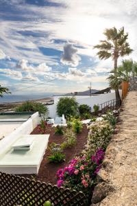 a garden with flowers and a view of the ocean at "NEW" Deluxe designer Villa Infinity, with Panoramic sea views,own exclusive heated private pool, subtropical gardens in Tías