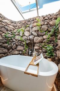 a bath tub in front of a stone wall at "NEW" Deluxe designer Villa Infinity, with Panoramic sea views,own exclusive heated private pool, subtropical gardens in Tías