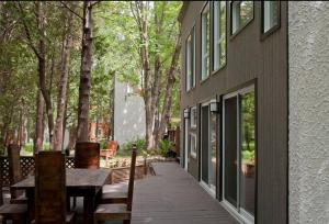 a patio with a table and benches next to a building at Le Cocon Orford Domaine Cheribourg in Magog-Orford