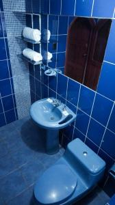 un bagno blu con un water e un lavandino di Eco Aventura Hostel Cusco a Cuzco