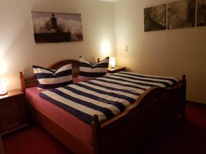 a bedroom with a bed with blue and white striped pillows at Kleine Auszeit in Stolpe auf Usedom