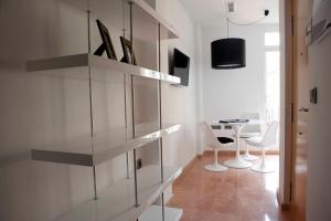 una habitación con estanterías de cristal y una mesa en ella en Happy Apartments Valencia – Lope de Vega, en Valencia