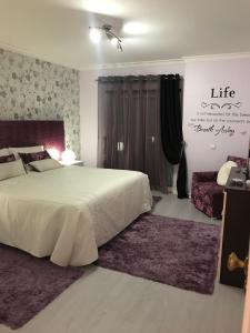 a bedroom with a large white bed with purple rugs at Timeless Vacations Vilamoura Marina Flat WIFI & Pool in Vilamoura