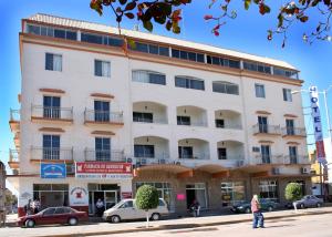 a white building with cars parked in front of it at Hotel Davimar in Guamúchil