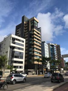 a large building with cars parked in front of it at Lindo Apartamento - Beira Mar de Boa Viagem in Recife