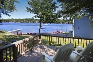a deck with chairs and a view of a lake at Delton Oaks Resort Motel in Wisconsin Dells