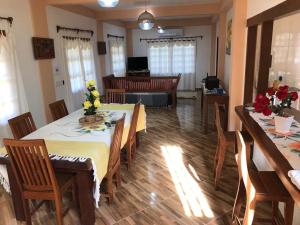 een eetkamer met 2 tafels en stoelen met bloemen erop bij Sitio damasio. Casas em Arraial d'Ajuda in Arraial d'Ajuda