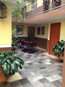 a room with a checkered floor and a table and chairs at Hotel Palacio in Uruapan del Progreso