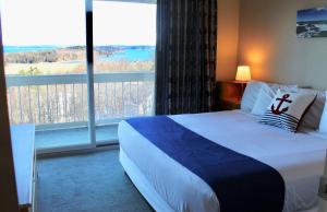 a hotel room with a bed and a large window at Atlantic Eyrie Lodge in Bar Harbor