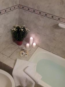 een badkamer met een bad, een toilet en kaarsen bij Hotel Biarritz in Frías