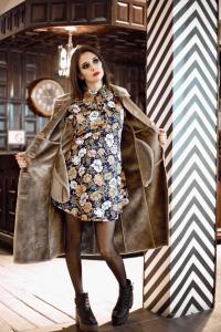 a woman in a floral dress wearing a trench coat at Hotel Biarritz in Frías
