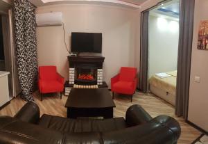 クルスクにあるStudio on Dimitrova 84のリビングルーム(ソファ、暖炉、赤い椅子付)