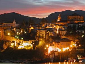 a city lit up at night with mountains in the background at Vistas de Ronda in Ronda