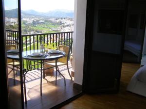 stół i krzesła na balkonie z widokiem w obiekcie Vistas de Ronda w mieście Ronda