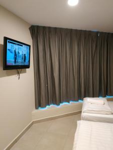 a room with a tv and a couch in front of a window at M Design Hotel @ Bangi 7 in Bangi