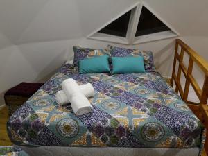 a bed with two towels and pillows on it at Domos y Cabañas Algarrobo in Algarrobo