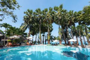 een groot zwembad met palmbomen op de achtergrond bij Paradise Beach Resort, Koh Samui - SHA Extra Plus in Mae Nam