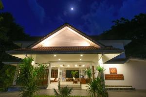 une maison la nuit avec la lune dans le ciel dans l'établissement Paradise Beach Resort, Koh Samui - SHA Extra Plus, à Mae Nam Beach