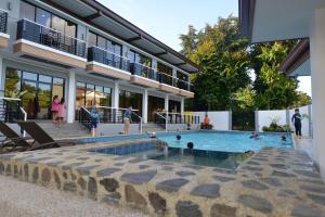 a swimming pool in front of a building with people in it at Hotel Gabriella in Tagbilaran City