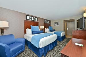 a hotel room with two beds and a tv at Wyndham Garden Elk Grove Village - O'Hare in Elk Grove Village +37 photos