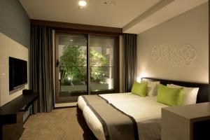 a bedroom with a bed with green pillows and a window at Futakotamagawa Excel Hotel Tokyu in Tokyo