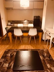 una stanza con tavolo e due sedie e una cucina di Hokkaido Bed & Bagel a Eniwa
