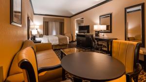 a hotel room with a bed and a table and chairs at Best Western Plus Airport Inn & Suites in Salt Lake City