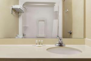 a bathroom with a sink and a mirror at Days Inn & Suites by Wyndham Thompson in Thompson