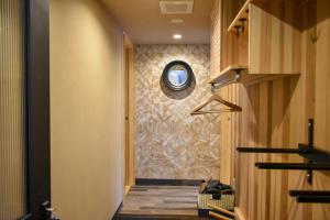 a hallway with a round mirror on a wall at Penke Panke Lodge and Apartments in Hakuba