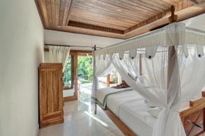 ein Schlafzimmer mit einem Bett mit Holzdecke in der Unterkunft Sama Sama Amed in Amed