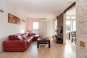 a living room with a red couch and a table at Luxury apartment SEA in Pula