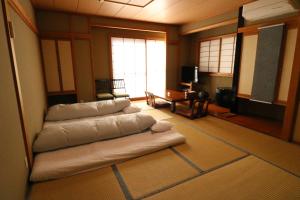 a living room with pillows on the floor at Wakamizusou in Fujikawaguchiko