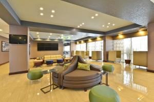 een lobby met een wachtkamer met een bank en stoelen bij Wyndham Garden Elk Grove Village - O'Hare in Elk Grove Village